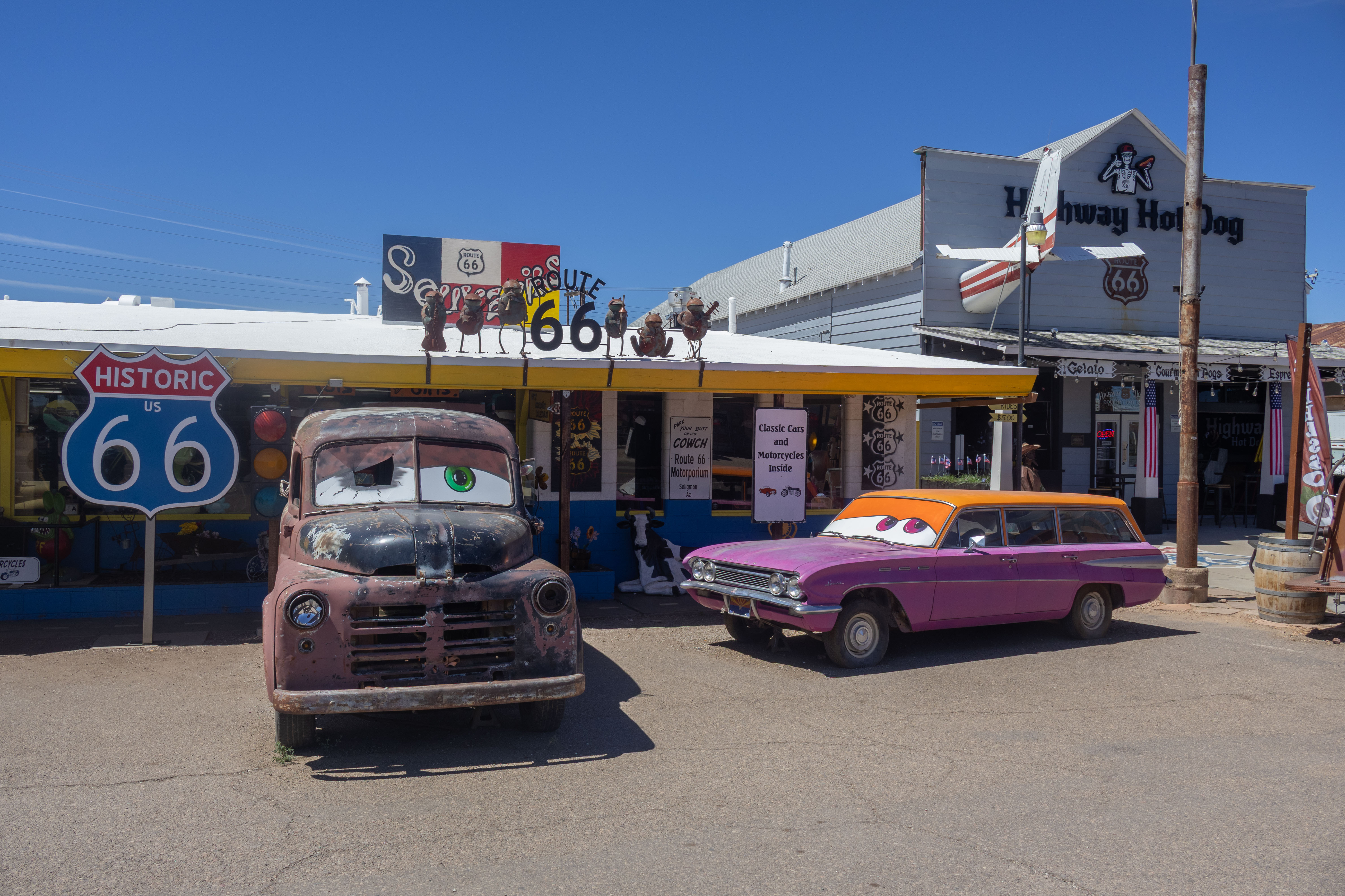 Two decorated cars parked in front of the Route 66 Motorporium in Seligman